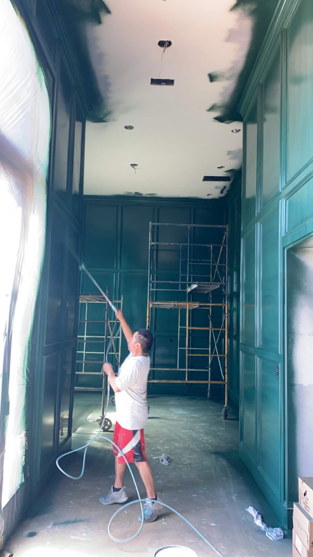 Professional painter spraying green panel interior entrance